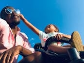 Happy father and daughter bonding moment outdoors under a clear blue sky.
